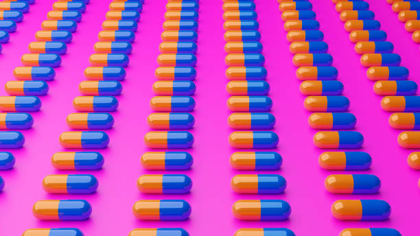 istock 3d illustration blue and yellow 3d pills on pink background 1352709505
