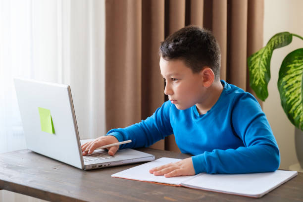 istock 8 years old cute child doing homework at home 1352709579