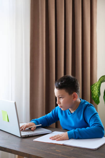 istock 8 years old cute child doing homework at home 1352709585