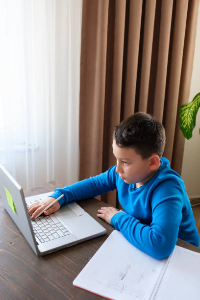 istock 8 years old cute child doing homework at home 1352710122