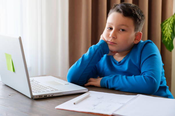 istock 8 years old cute child doing homework at home 1352710139
