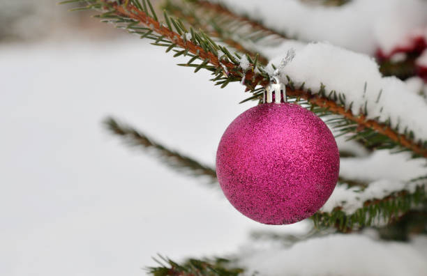 istock Red glass Christmas ball on Christmas tree with snow as background 1352713672
