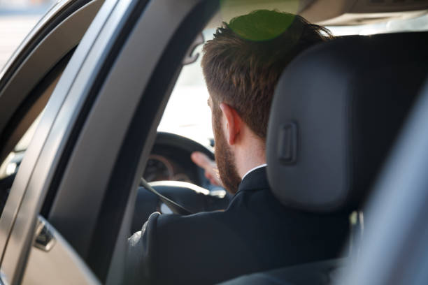 istock View from back of Business man driving car 1352714854