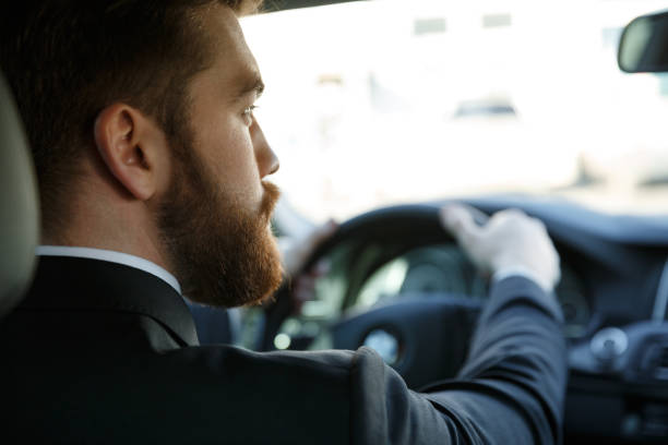 istock Young bearded business man driving car 1352714924