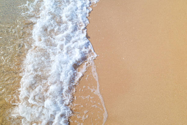 Water from ocean hitting sand.