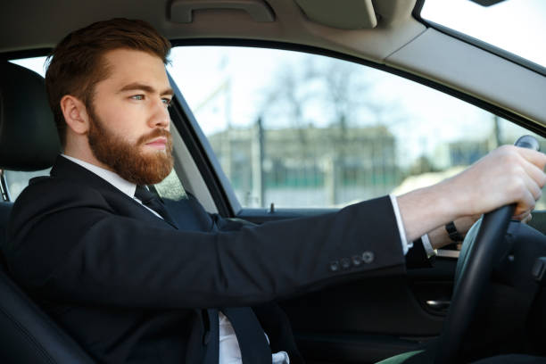istock Handsome young business man driving his car 1352715213
