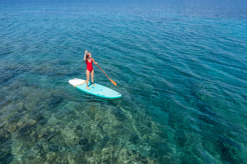 Aerial view of woman on a stand up paddle