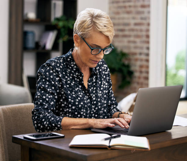 istock Shot of a mature woman using her laptop while working from home 1352715407