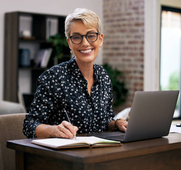 istock Shot of a mature woman using her laptop while working from home 1352715411