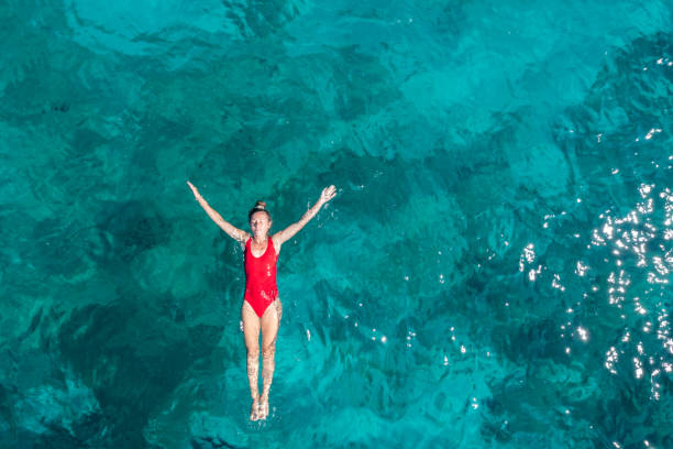 istock Woman floating turquoise sea 1352715697
