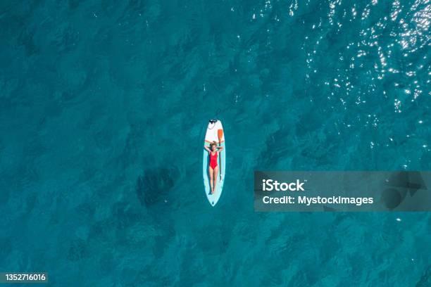 Aerial View Of Woman Floating On A Stand Up Paddle Stock Photo - Download Image Now - Beach, Aerial View, Paddleboarding