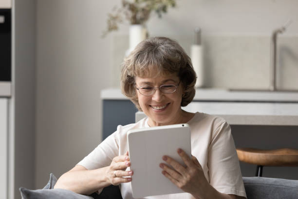 istock Happy beautiful middle aged woman using digital tablet. 1352716027
