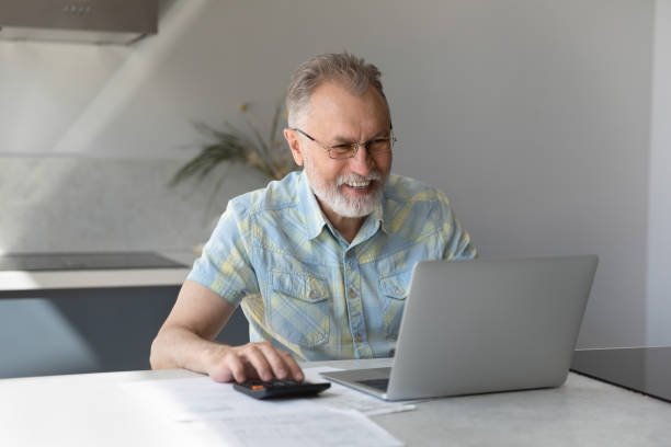 istock Happy old mature man calculating household budget. 1352716069