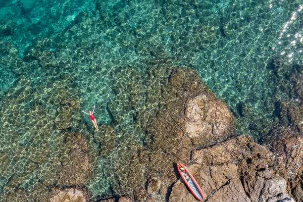 istock Woman floating turquoise sea 1352716078
