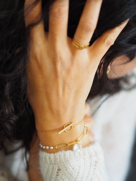 istock Gold bracelets accumulation on a woman wrist wearing a white wool winter pullover 1352718081