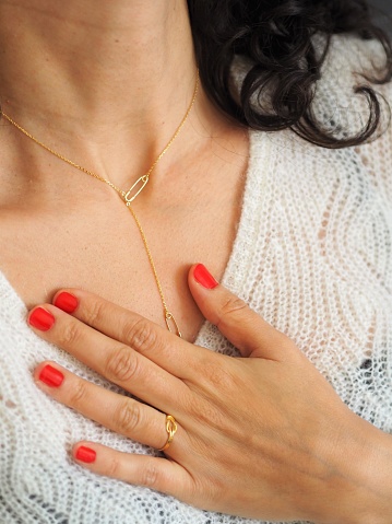 Safety Pin Necklace and ring on a white wool pullover