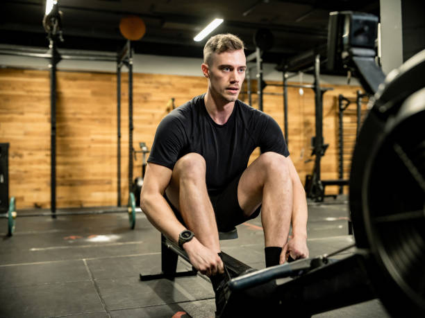 istock Young man exercising on rowing machine in the Gym 1352721883