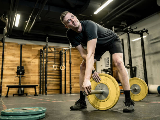 istock Young Man lifting weights in the Gym 1352722602