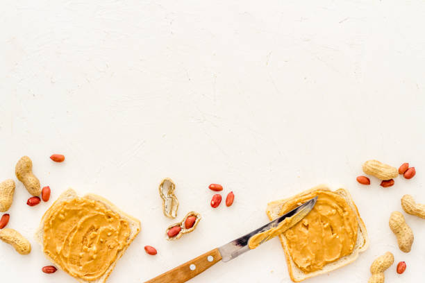 istock Smooth peanut butter on sandwiches with nuts. Top view 1352724137