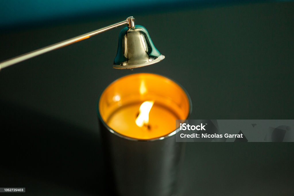 A candle 3 An extinguisher above a candle on a table Candle Snuffer Stock Photo