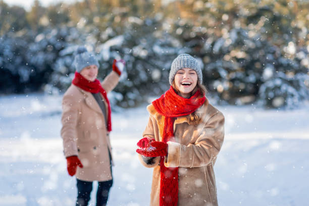 istock Joyful romantic couple having snow fight at winter forest 1352726767