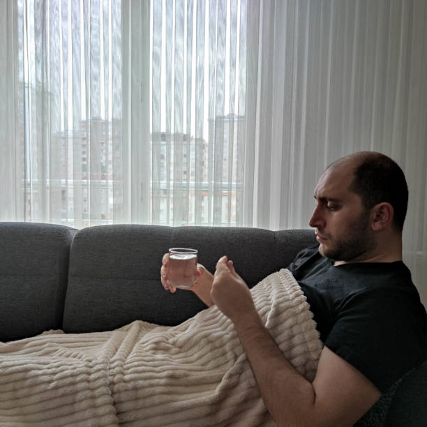istock Patient lying on sofa armchair taking medications on table 1352727000
