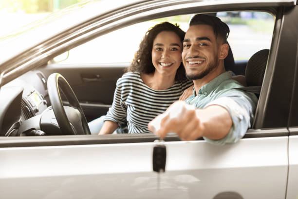 istock Happy young middle-eastern couple showing key from car 1352727088