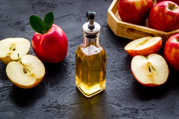 istock Bottle of organic apple cider vinegar with red apples 1352727298