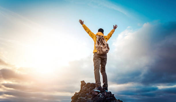 menschenreisender auf berggipfel genießt naturblick mit erhobenen händen über wolken - sport, reise business und erfolg, führungs- und leistungskonzept - risk mountain climbing climbing conquering adversity stock-fotos und bilder