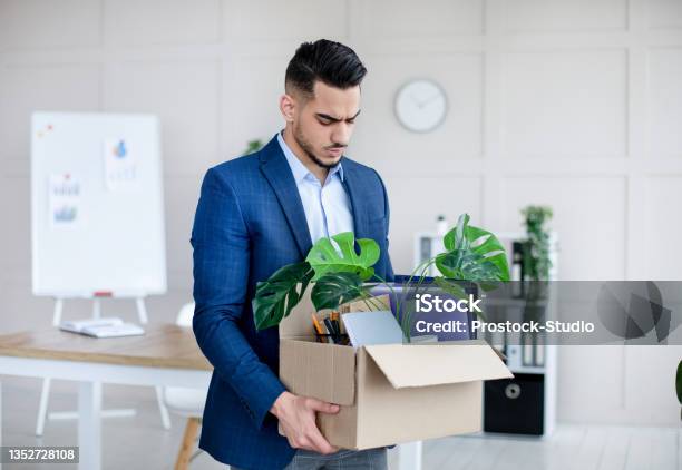 Unemployed Arab Guy In Formal Wear Holding Personal Belongings Feeling Depressed After Losing His Job Stock Photo - Download Image Now