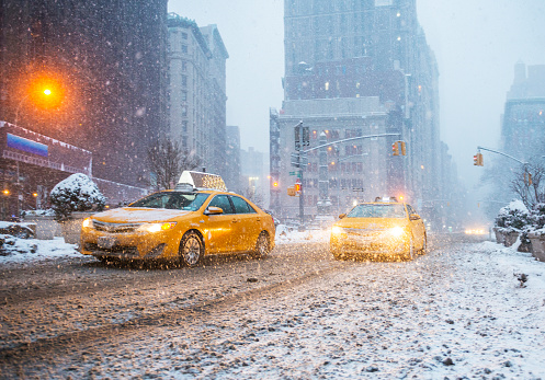 Yellow taxis moving under heavy snow in New York City, USA