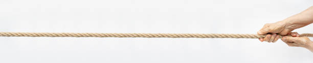 istock Tug of war. Aged wrinkled hands pull the rope towards themselves. Horizontal web banner for your text. 1352729467