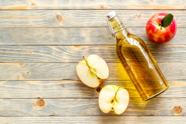 istock Bottle of organic apple cider vinegar with red apples 1352729510