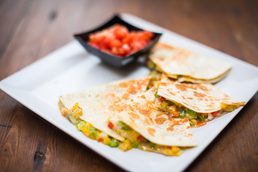 Color close up shot of some quesadilla slices on a plate.