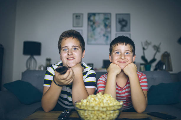 istock Boys watching a movie at home at night eating popcorn 1352732005