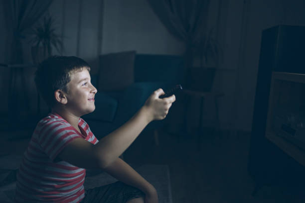 istock Boy in front of tv at night at home 1352732011