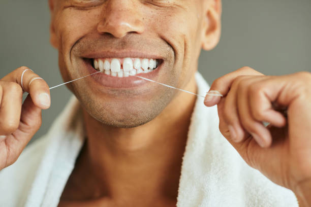 istock Close-up of man using dental floss. 1352734329
