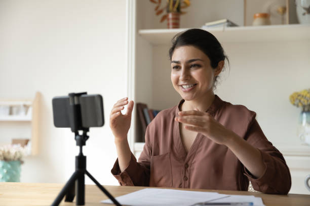 istock Indian woman record videovlog on cellphone seated at table 1352734379