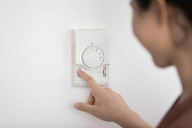 istock Woman setting temperature inside for economy and comfort 1352734412