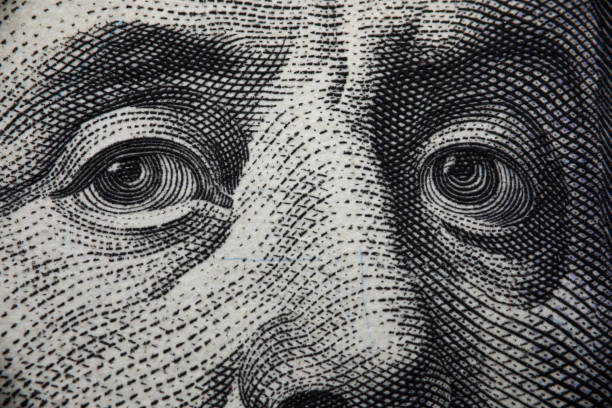 istock Close-up of benjamin franklins face on hundred banknote 1352737568