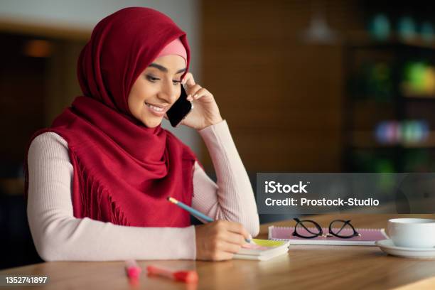 Beautiful Muslim Woman Talking On Cellphone At Cafe Stock Photo - Download Image Now