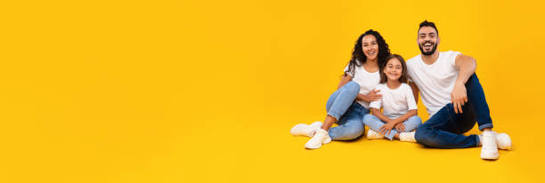 istock Cheerful Arabic Family Posing Embracing Sitting In Studio, Yellow Background 1352742261