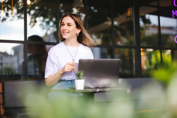 istock Relaxed Young Woman Working on Laptop in Cafe 1352744398