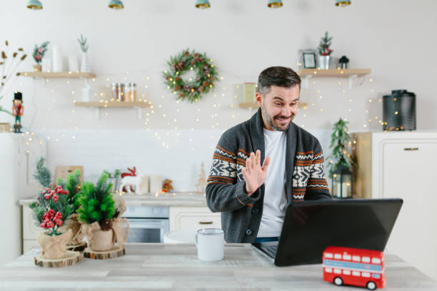 istock Man working from home communicates with colleagues and friends via video link, using a laptop, for the New Year and Christmas holidays 1352747275