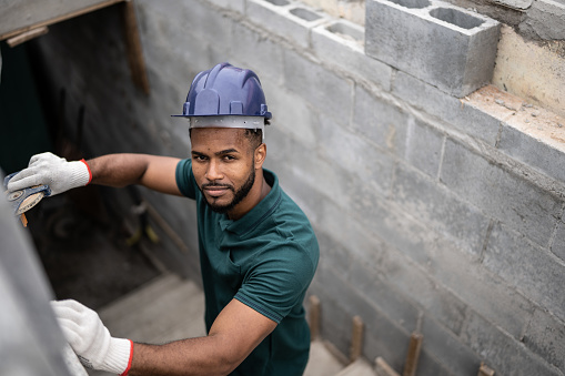 Portrait of a construction worker building a brick wall