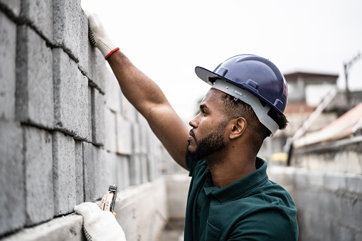 Construction worker building a brick wall
