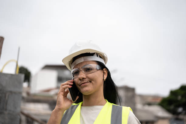 female engineer talking on the phone in a construction site - female construction telephone building contractor imagens e fotografias de stock