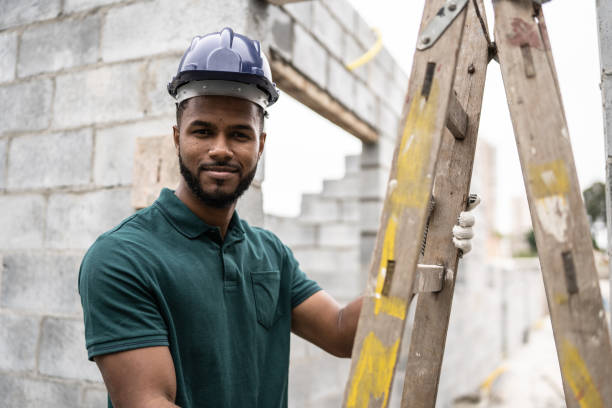 istock Portrait of a construction worker holding a ladder in a construction site 1352748779