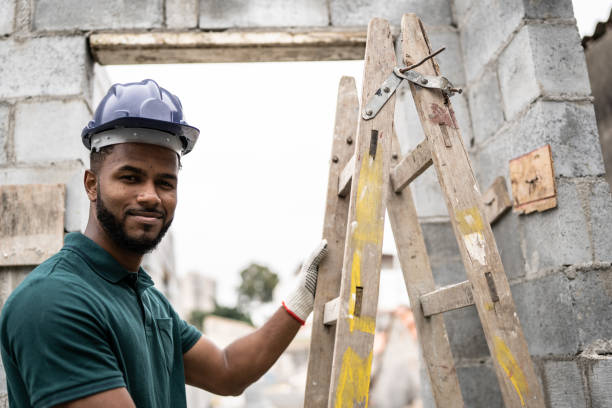 istock Portrait of a construction worker holding a ladder in a construction site 1352748797