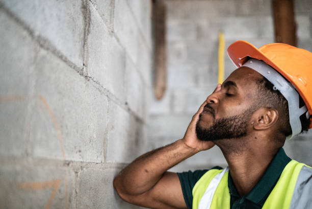 un ouvrier de la construction inquiet analyse un chantier de construction - protective workwear bricklayer manual worker construction photos et images de collection